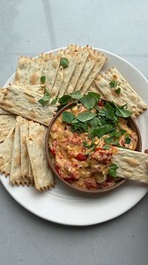 Baked Tomato Dip - it's easy for summer entertaining because you can just throw everything in a dish and then serve it with crackers hot or cold! 🍅 INGREDIENTS 1 pint cherry tomatoes ¼ cup sliced green olives 4 garlic cloves, unpeeled ¼ cup chopped red onions 3 tablespoon extra virgin olive oil 1 block 8 ounces chèvre ¼ teaspoon crushed red pepper Fresh basil for garnish Rosemary crackers for serving INSTRUCTIONS 1. Preheat oven to 400°F. 2. In an oven safe dish, place the cherry tomatoes, oliv