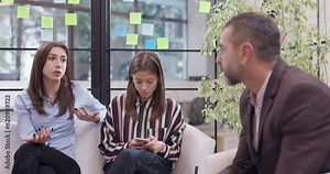 Young female colleagues discussing work related problems with senior supervisor. Start up business team having a brainstorming meeting at modern office space.