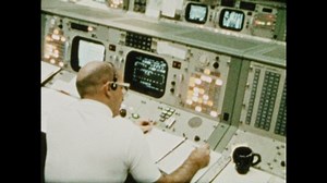 1970s: UNITED STATES: flight controls at mission control. Television footage of astronauts in space. Astronaut talks to public during transmission. View of Earth from space.