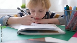 Elementary student boy doing math homework at home.Child learning to count, solves arithmetic examples, doing exercises in workbook. Preparing preschooler for school.Education for kids.Focus on hand Stock Video