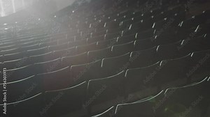 Empty spectator seats at projectors light in amphitheater auditorium. Comfortable chairs waiting for visitors in music hall. Interior design