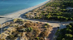 People walking toward ammo Jetty along Woodman Point Beach, Perth City Suburbs in Western Australia. Aerial forward and slow-motion