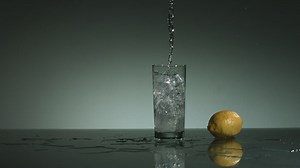 Water falling into a glass with ice cubes - Free Stock Video