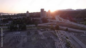 High voltage power transmission tower and lines near a transformer station, aerial footage, electricity, city grid, infrastructure, sunset. 4K 24FPS Stock Video