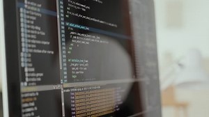 Unrecognizable programmer studying coding on computer monitor