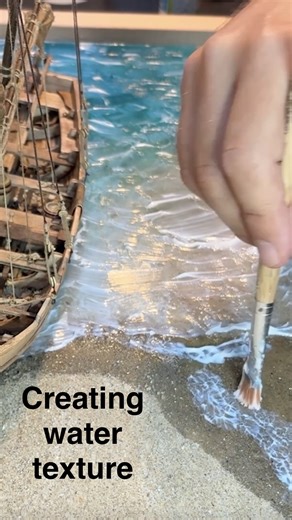 Creating waves and wrinkled water structure using Gel splash (dries transparent). From shaping the sandy shore, positioning the boat, pouring the sea, adding realistic water movement, to finishing the scene with small details that bring it all to life. Each post will focus on a key stage of the process. Follow along if you enjoy miniature scenes, realistic water effects, and ship model dioramas. More reels coming soon! #ScaleModel #modelship | Curtis_Wooden_Shipyard