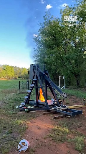 Interesting Engineering on Instagram: "A counterweight trebuchet launches a flaming projectile by converting gravitational potential energy into kinetic energy through rotational acceleration. 🎥 fortinthewoods / TT"