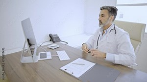 Doctor in a doctor's office typing a medical report on computer