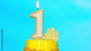 Birthday cake with one burning candle for first birthday. Celebration background.