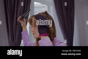 Beautiful blonde young woman in process of hair styling, rearranges strands, home daily hair routine, beauty tutorial Stock Video Footage - Alamy