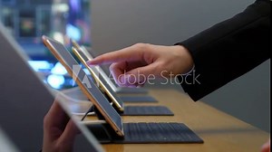 Woman try updated model of tablet computer in store showroom, closeup shot of female hands and new thin portable device standing on support with keyboard attached