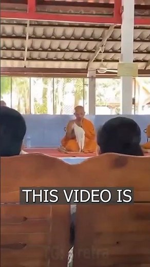 A cat is preventing a Buddhist monk from praying