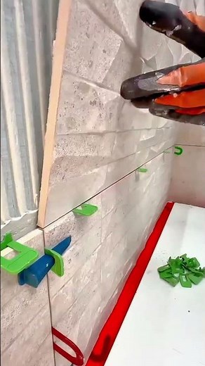 installing the light grey textured wall tiles on the white wall for a neat home interior finishing