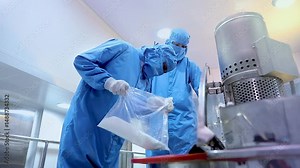 pharmaceutical workers in industrial stainless steel vessels in cosmetic manufacturing factory for cream, lotion, gel, or liquid production with automated mixing, batching, and processing equipment.