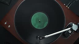 At the beginning, a close-up view of a spinning vinyl record with a...