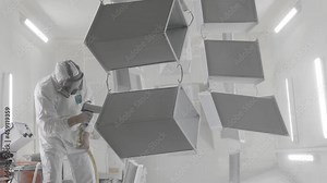 Industrial painting metal powder coating paint manufacturing process. Powder coating of metal products. Coveralls worker with spray gun painting parts metal workshop. Metalwork workpiece factory paint