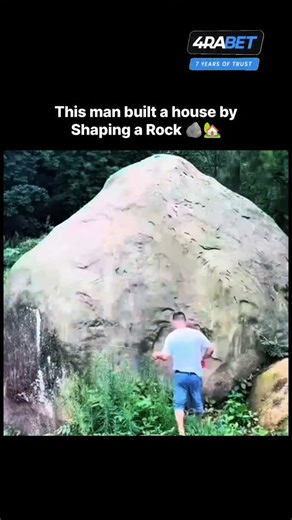 World_War on Instagram: "This video is a still from a viral video showing a man building a hidden house inside a massive rock. The man is seen using simple tools and natural materials to carve out a shelter under a large stone overhang. The construction is often presented as a survival or bushcraft project, built alone in a remote forest or mountain area. The videos typically document the entire process from the start of the excavation to the final interior details, such as a stove or bed. The p