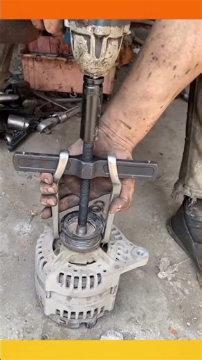 Using a puller impact wrench to safely remove alternator pulley during a mechanical repair process.