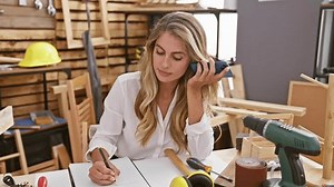 clip-3392558521-stunning-blonde-woman-passionate-about-woodwork-hunkered
