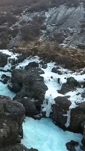 Hraunfossar isn’t your typical waterfall, it flows through lava! 🌋 The name means “Lava Falls,” and the water seeps from underground springs between layers of hardened lava rock. 🖤 Pro tip: Visit in autumn or winter — the contrast with snow or fiery foliage is unreal. 🍂❄️ | Guide to Iceland