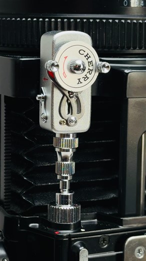 Cherry Self Timer-L is a vintage Japanese-made mechanical accessory that screws into a camera's threaded shutter release socket for delayed triggering (ideal for self-portraits or group shots). It features a chrome metal body, wind-up dial with "CHERRY" branding and arrows, and distinctive extending "wings" in the final seconds before release. | GIGadgets