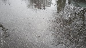 slow motion full-frame view of wet asphalt under rainfall, real life ugc cellphone made footage