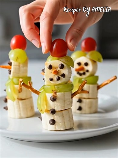 Adorable Banana Snowmen ☃️🍌 A healthy and festive treat that's almost too cute to eat! 🍇❄️ #WinterSnacks #HealthyHoliday #KidFriendlyFood #FruitArt #ChristmasTreats | Recipes By Amelia