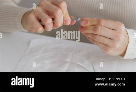 Womans hands using a cuticle nipper to perform a manicure on a white table Stock Video Footage - Alamy
