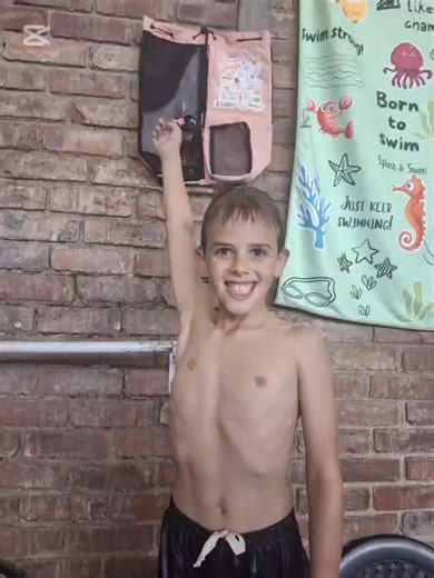 Finley the Elf’s Selfie Surprise Finley is officially done with all his sneaky hiding for now. After days of playing games, watching quietly, and giggling behind swimming bags, he decided it’s time for something special. This morning, the kids walked into Fishdom Swim School and found Finley sitting proudly on a little ledge—legs crossed, hat straight, and the biggest cheeky grin on his tiny face. Instead of hiding, he was posing. A shiny cardboard “Selfie Spot” sign stood next to him. Finley ha