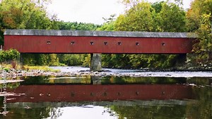 Red covered bridge in west cornwall connecticut reflected in housatonic river profile wide II