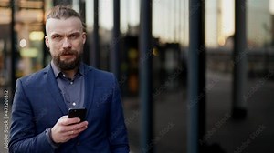 boss is checking email by app in smartphone and sending message walking in street