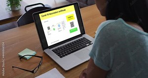 Woman working at desk, covid vaccination certificate with qr code on laptop screen Stock Video