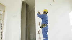Plumber busy taking photos of construction site for work reference for insurance claim - concept of measuring digitally using smartphone technology.