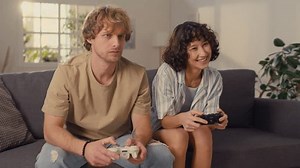 Moyenne photo de jeune couple assis sur un canapé avec des contrôleurs gagnant des jeux vidéo de compétition
