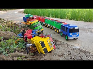 A long truck full of cars, excavators, cranes, bulldozers, and fire trucks overturned.