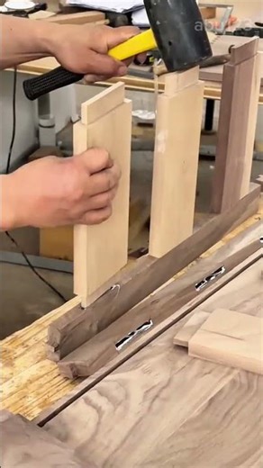 Assembling Wooden Drawer Components Using a Rubber Mallet and Joinery Techniques in a Furniture