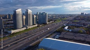 Toronto, Ontario Highway 401 during sunset with busy traffic and transport trucks delivering goods; aerial 4K