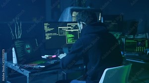 Portrait of sinister computer hacker working with codes breaking into security system in the company office at night.