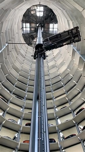 Archisource on Instagram: "Volkswagen Car Towers at Autostadt in Wolfsburg, Germany - captured by @anlinsh • Project designed by @hennarchitecture - The 48 metre tall towers store up to eight hundred new cars. The fully automated high racks move an average of five hundred cars to be delivered and picked up every day. Made of glass and galvanized steel, a conveyor belt system transports finished cars directly from the adjacent manufacturing plant to the towers’ basement. @autostadtvw @autostadt @
