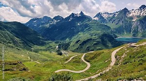 Scenic Alpine Landscape with Winding Roads and Lush Greenery Around a Mountain Lake