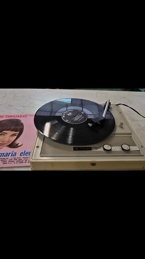 giradischi portatile vintage Reader's Digest modello 304. È un modello degli anni '60 o '70, noto anche come fonovaligia, che integra un altoparlante. Permette la riproduzione di dischi in vinile a diverse velocità: 33, 45 e 78 giri. Presenta controlli per il volume e il tono, visibili sul pannello frontale. Il design è compatto e retrò, tipico dell'epoca in cui è stato prodotto. | Mercatino Dell'Usato Alla Locomotiva