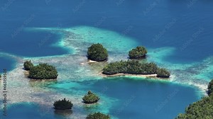 Cluster of tropical islets with turquoise ocean water and corals. Britania Islands. Surigao del Sur, Philippines. Zoom view.