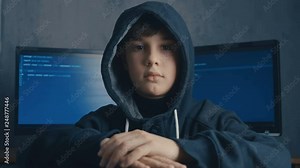 Wanted Prodigy Boy Hacker in the data center filled with display screens. Portrait of Child prodigy hacker.