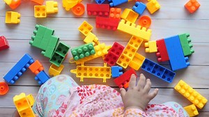 Download A child's hands are surrounded by colorful blocks for free