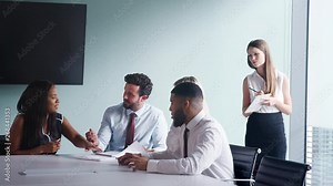 Group Collaborating On Task At Graduate Recruitment Assessment Day Whilst Being Observed By Recruitment Team