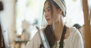 Beautiful asian stylish female artist painting picture in art studio. Young woman painter draws with paint brush and oil colors creating artwork sunset landscape on canvas. imagination and creativity.