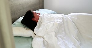 clip-1084332037-woman-waking-morning-person-lying-bed-under