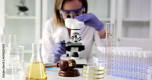 Medical examiner looks through a microscope and examines evidence from crime scene. Independent forensic medical examination