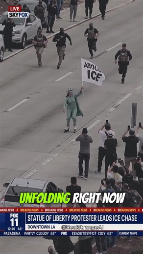 Lady Liberty apparently traded the torch for roller skates 😭 A protester dressed as the Statue of Liberty waves an “ABOLISH ICE” sign while agents chase behind in this absurd parody scene. Anti-ICE demonstrations have included protesters dressed as Lady Liberty in Los Angeles. #AbolishICE #ICEProtest #StatueOfLiberty #LosAngeles #StrangeAI