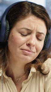 Vertical Video Female entrepreneur enjoys multitasking with her favorite music on headset, singing and dancing at her CEO desk. Woman with leadership skills working on her business with songs. Camera